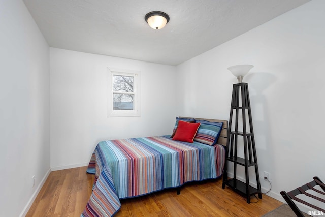 bedroom featuring baseboards and wood finished floors