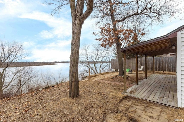 exterior space with a water view and fence