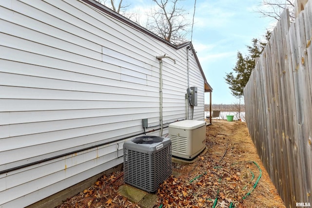 view of side of property featuring central AC and fence