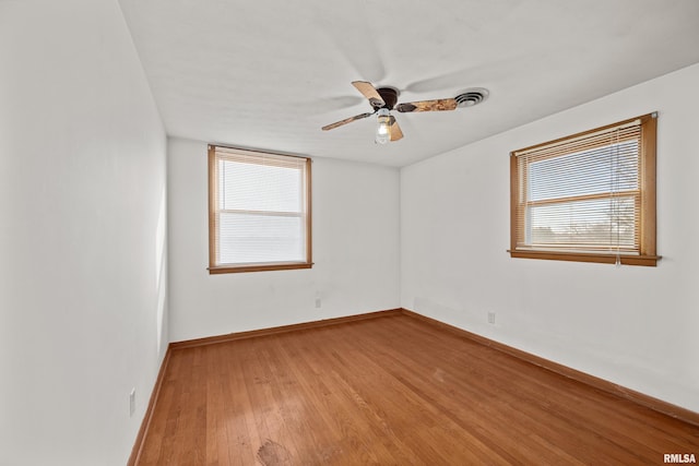 unfurnished room with hardwood / wood-style flooring, ceiling fan, and a wealth of natural light