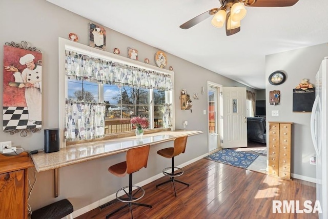 bar with baseboards, dark wood-style flooring, ceiling fan, and freestanding refrigerator