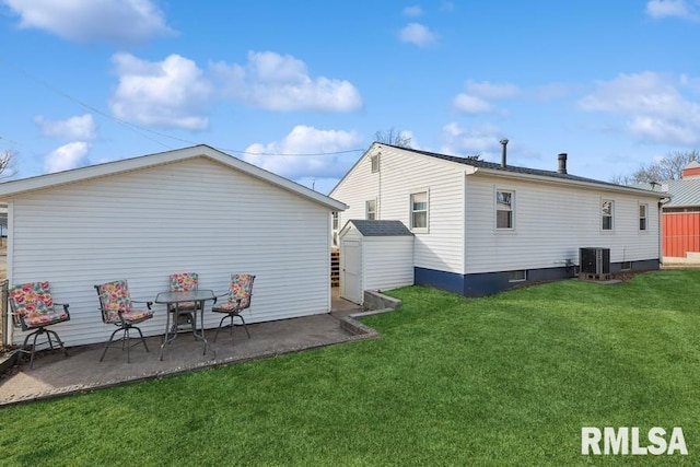 back of property featuring a storage unit, a lawn, an outdoor structure, a patio area, and cooling unit