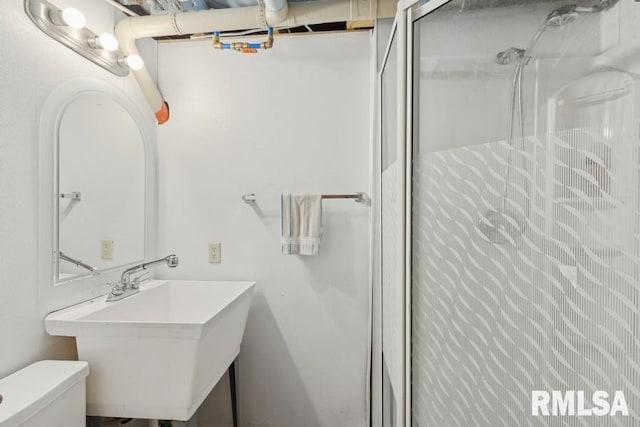 bathroom featuring toilet, a sink, and walk in shower