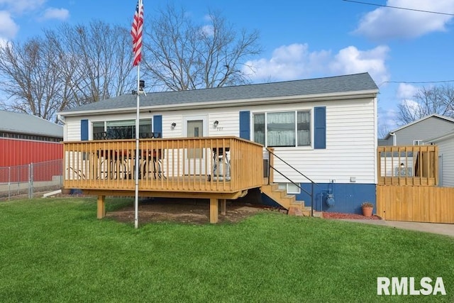 rear view of property with a deck and a lawn