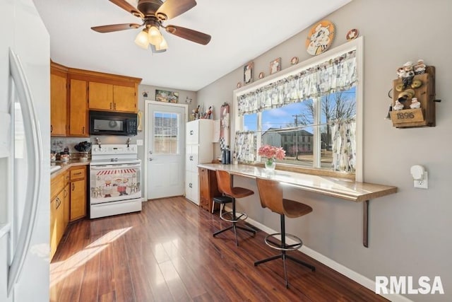 kitchen featuring brown cabinets, white appliances, light countertops, and dark wood-style flooring