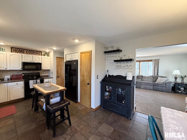 kitchen featuring dark countertops, backsplash, black appliances, baseboards, and white cabinetry