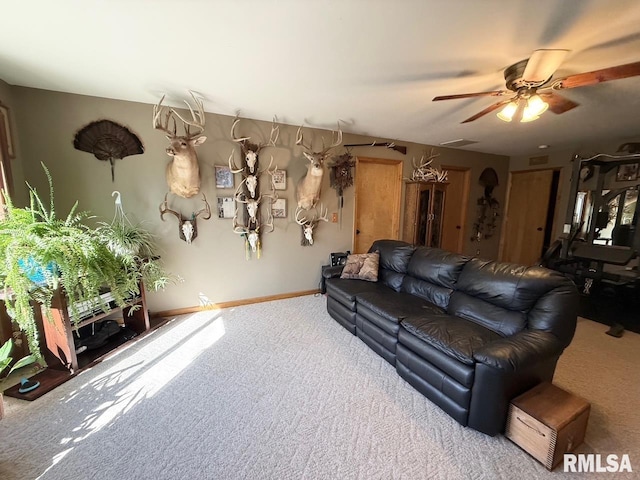 carpeted living area featuring ceiling fan and baseboards