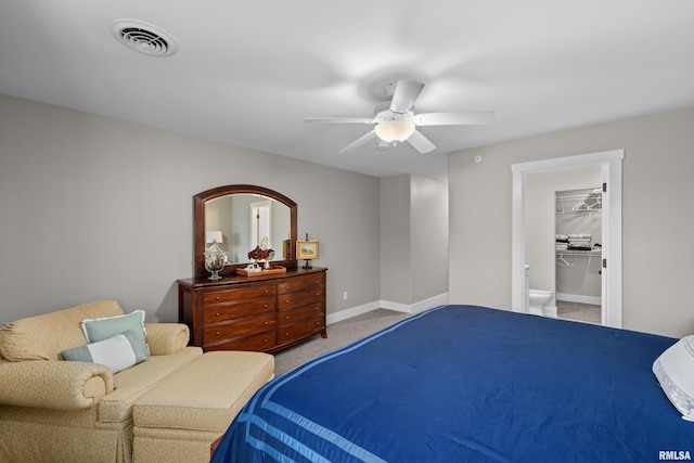 carpeted bedroom with a walk in closet and ceiling fan