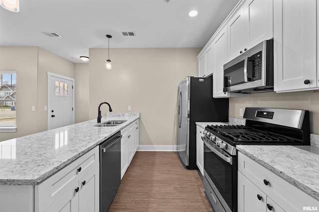 kitchen with white cabinetry, appliances with stainless steel finishes, sink, and pendant lighting