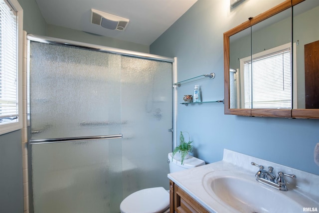 full bathroom featuring toilet, a healthy amount of sunlight, and a shower stall