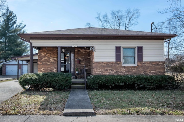 view of front facade featuring a garage, brick siding, a porch, and an outdoor structure