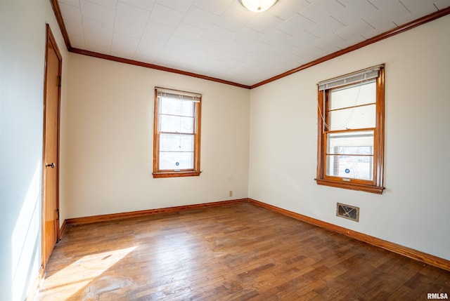 empty room featuring crown molding and wood-type flooring