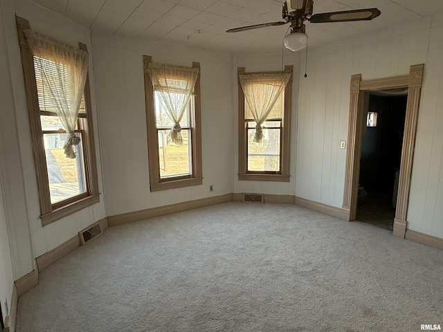 carpeted spare room with ceiling fan and a healthy amount of sunlight