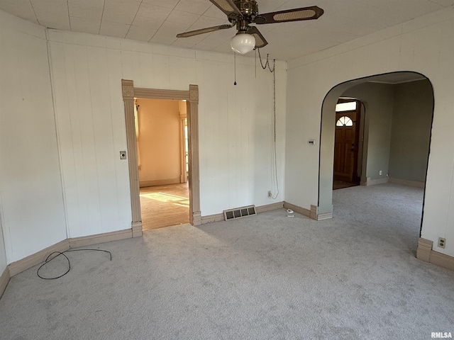 empty room featuring ceiling fan and light carpet