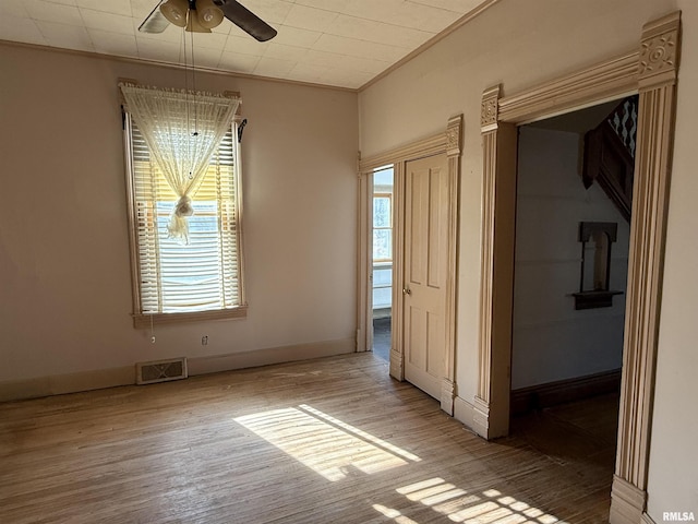 unfurnished room featuring light hardwood / wood-style flooring, ornamental molding, and ceiling fan