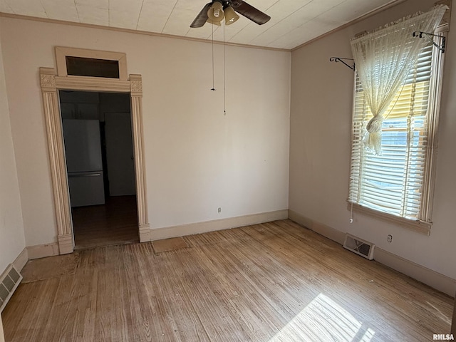 empty room featuring hardwood / wood-style flooring, crown molding, and ceiling fan