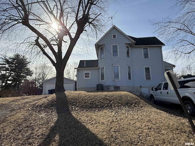 view of home's exterior with an outbuilding, a garage, and central AC