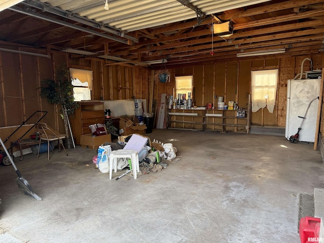 garage with a garage door opener and white fridge