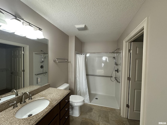 bathroom featuring vanity, a textured ceiling, toilet, and walk in shower