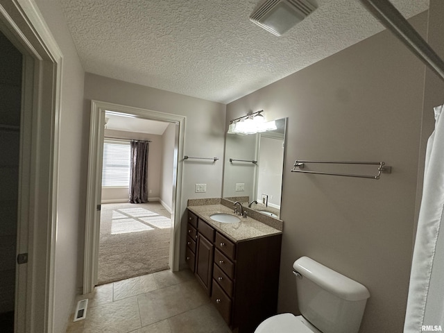 bathroom with vanity, a textured ceiling, and toilet