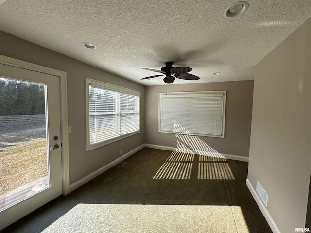 unfurnished sunroom featuring ceiling fan