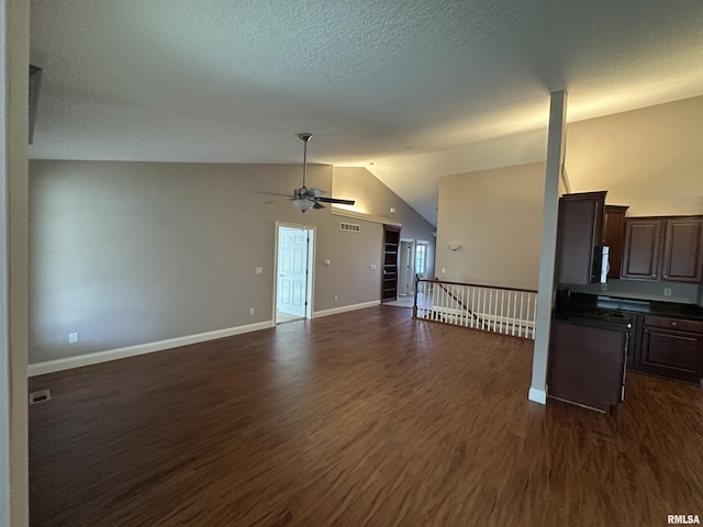 unfurnished living room featuring ceiling fan, lofted ceiling, dark hardwood / wood-style floors, and a textured ceiling