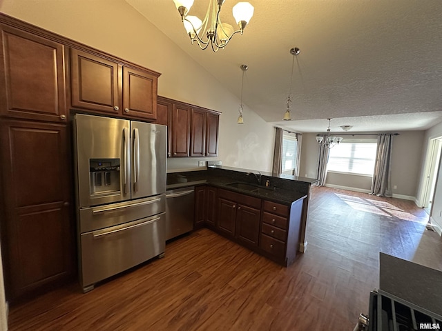 kitchen with appliances with stainless steel finishes, a chandelier, sink, and hanging light fixtures