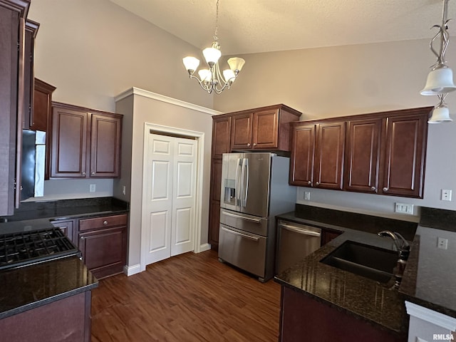 kitchen featuring appliances with stainless steel finishes, sink, pendant lighting, and dark hardwood / wood-style flooring