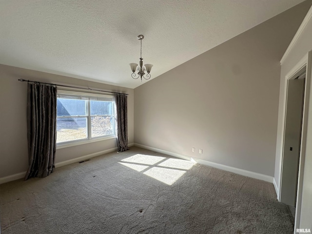 unfurnished room with carpet floors, a textured ceiling, vaulted ceiling, and a chandelier