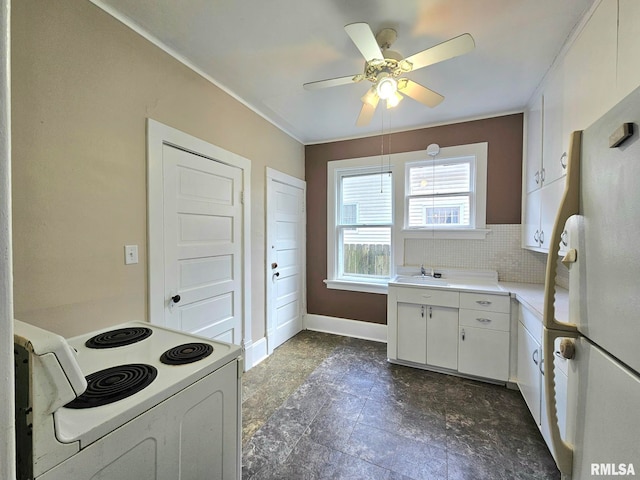 620 Sycamore St, Muscatine, IA 52761 - kitchen with a sink, white appliances, white cabinets, light countertops, and baseboards