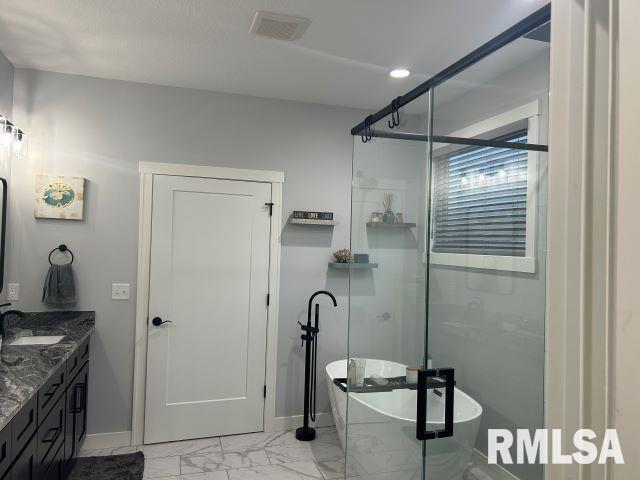 bathroom featuring vanity and independent shower and bath