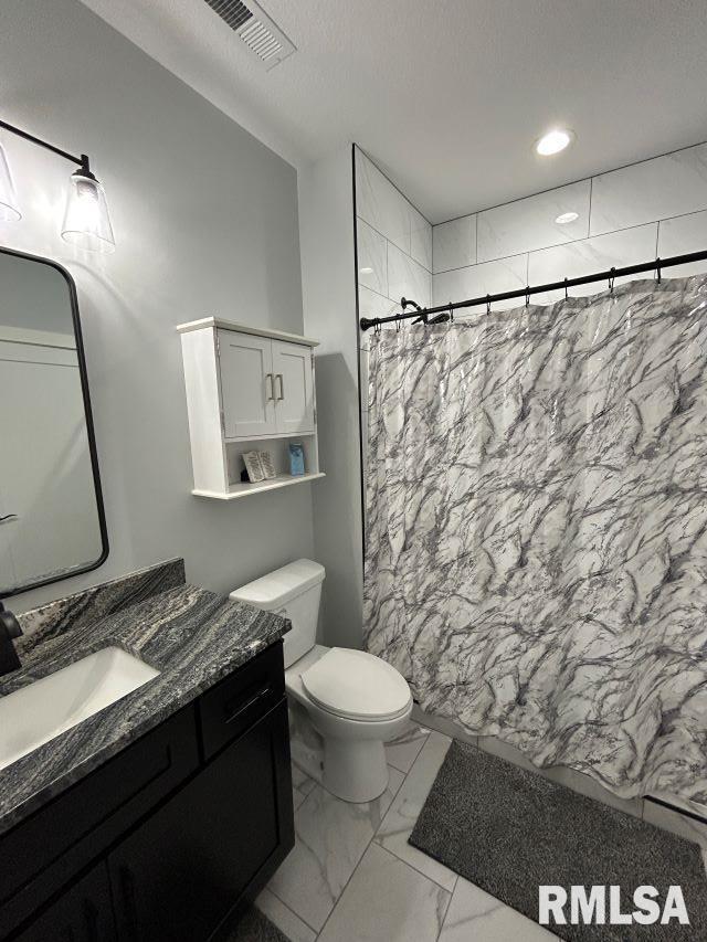 bathroom featuring a shower with curtain, vanity, and toilet