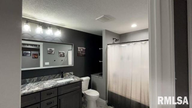 bathroom featuring vanity, walk in shower, a textured ceiling, and toilet