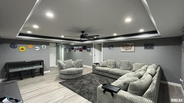 interior space featuring ceiling fan, a tray ceiling, and light hardwood / wood-style flooring