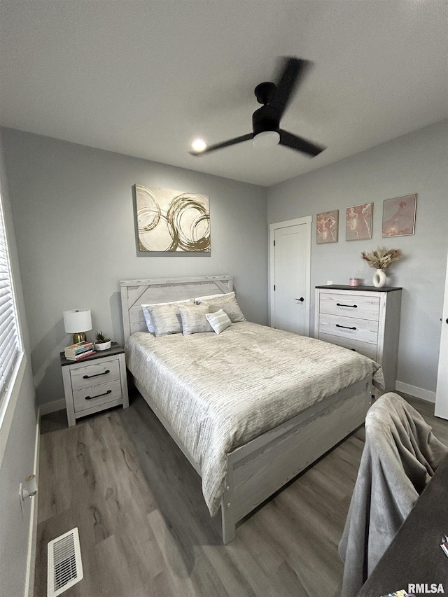 bedroom with dark hardwood / wood-style floors and ceiling fan