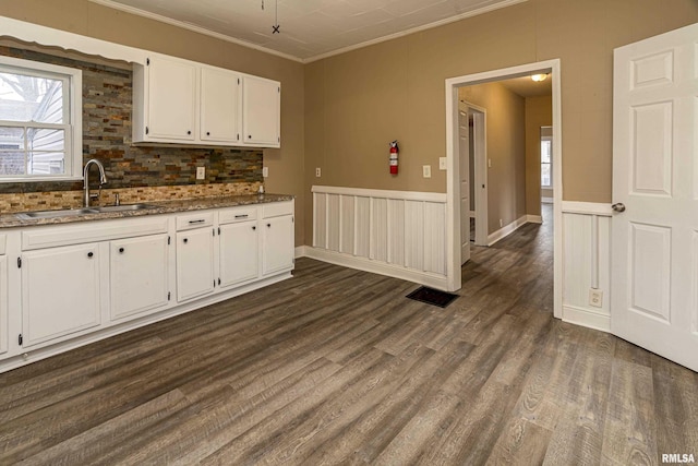 kitchen with sink, white cabinets, decorative backsplash, crown molding, and dark wood-type flooring