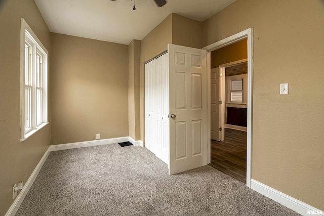 unfurnished bedroom with carpet floors, a closet, and ceiling fan