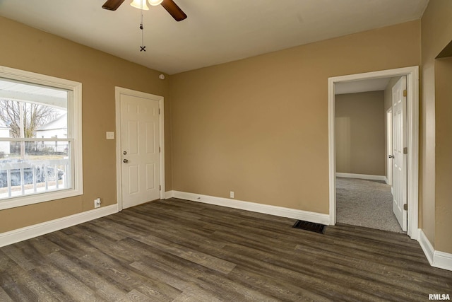 empty room featuring dark wood-type flooring and ceiling fan