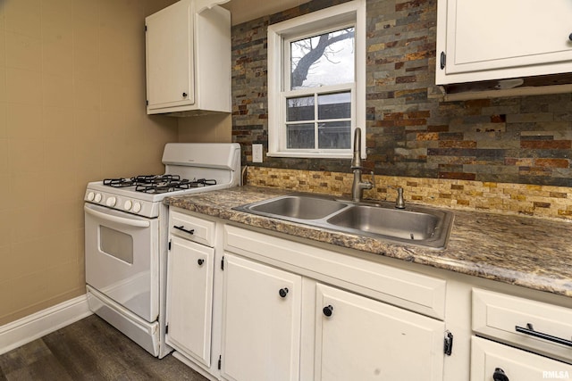 kitchen with sink, dark wood-type flooring, white range with gas stovetop, white cabinetry, and tasteful backsplash