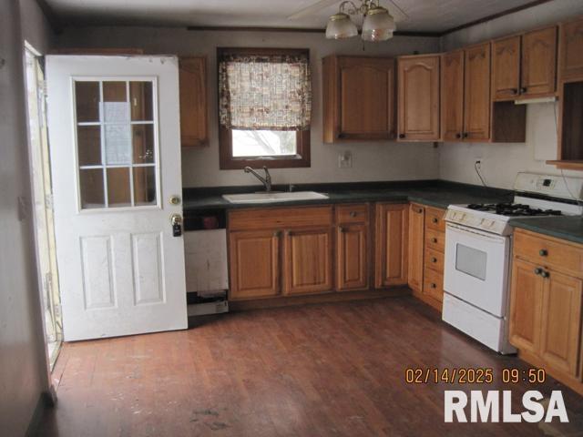 kitchen with stainless steel dishwasher, sink, white gas stove, and dark hardwood / wood-style flooring