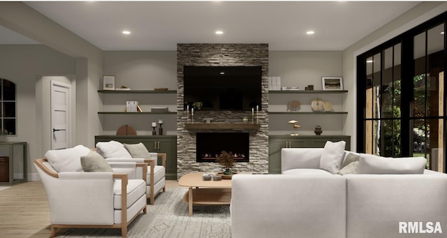 living area with recessed lighting, a stone fireplace, and wood finished floors