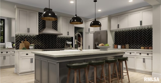 kitchen with light wood-style floors, a kitchen island with sink, stainless steel fridge, and backsplash