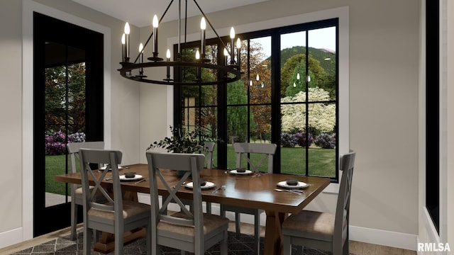 dining space with baseboards and a chandelier