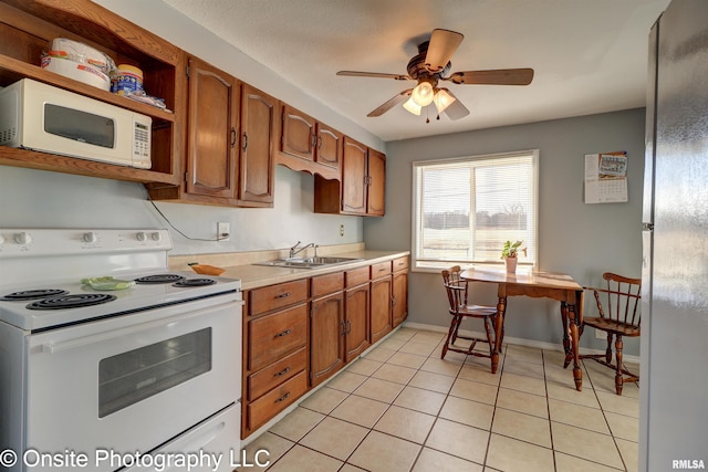 kitchen featuring ceiling fan, white appliances, sink, and light tile patterned floors