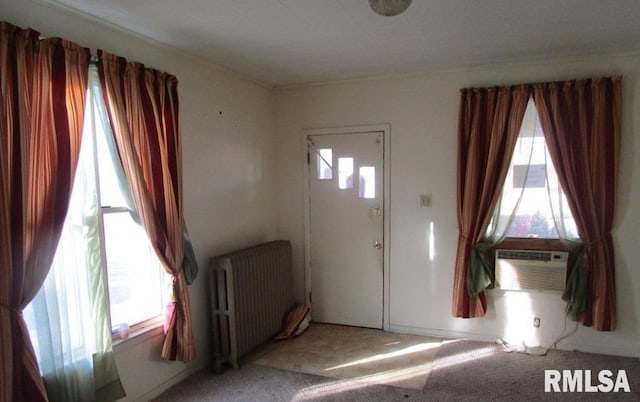 carpeted foyer entrance with radiator and cooling unit