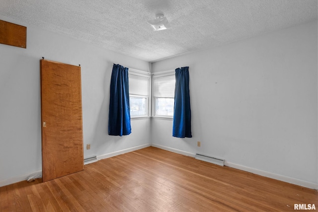 empty room with hardwood / wood-style flooring and a textured ceiling