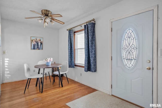 foyer entrance with ceiling fan, hardwood / wood-style flooring, and a textured ceiling