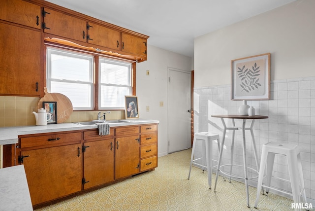 kitchen featuring sink and tile walls