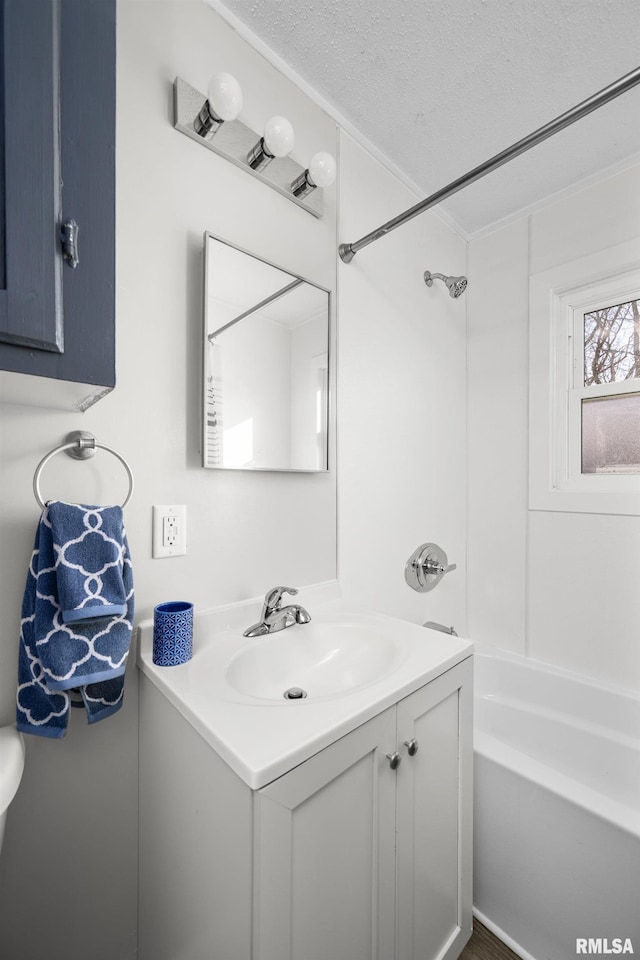 bathroom featuring shower / bath combination, vanity, and a textured ceiling