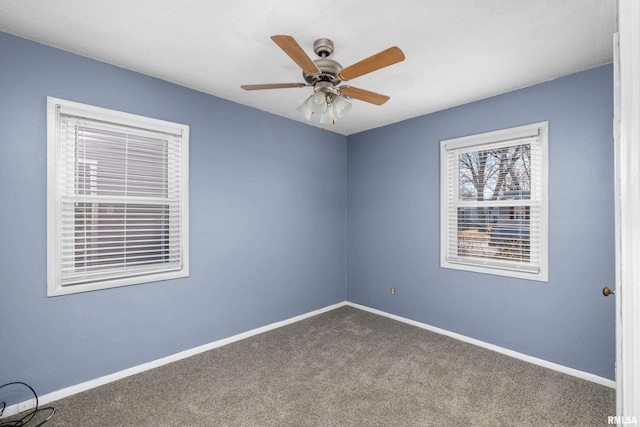 carpeted spare room with a textured ceiling and ceiling fan